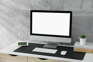 Fototapeta premium Stylish workplace with computer and black mousepad on white table indoors. Space for text