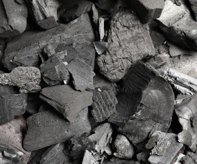 Pieces of black coals as background, top view