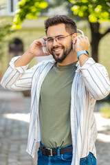 Joyful relaxed overjoyed young bearded man listening favorite energetic disco rock n roll music...