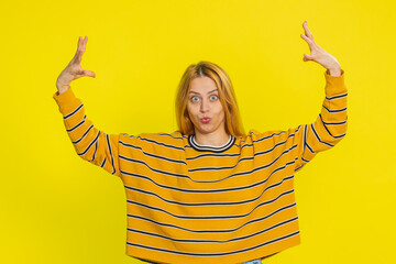 Amazed shocked excited Caucasian blonde woman in blouse touching head and showing head explosion,...