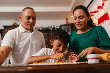 Hispanic family baking Christmas cookies together in home kitchen