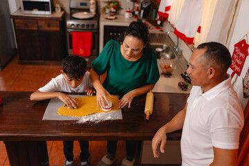 Top view of family preparing Christmas cookies in festive kitchen