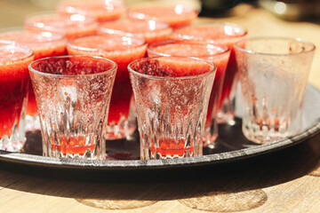 Fruit shots in glasses. Fresh berry drinks on tray. Summer party vibe with colorful cocktails....