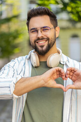 I love you. Caucasian man makes symbol of love, showing heart sign to camera, express romantic...