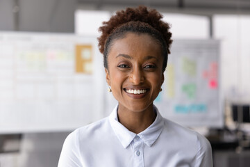 Head shot portrait of self-assured African businesswoman, project manager, smile, look at camera...