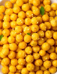 Traditional Indian sweet Laddu (Ladoo) made from gram flour, garnished with fresh curry leaves, perfect for festive celebrations and cultural occasions.