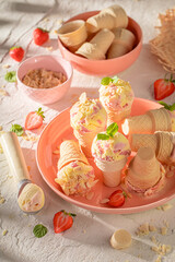Homemade and delicious strawberry ice cream in a waffle cone.