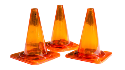 Three orange traffic cones arranged closely together on a black background in a studio setting