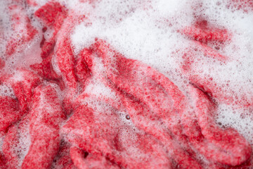 Red Cashmere Sweater Being Soaked in Soapy Water