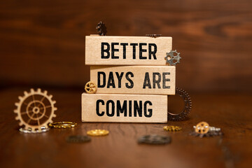 Better Days Are Coming text written on notepad with alarm clock on pink background.