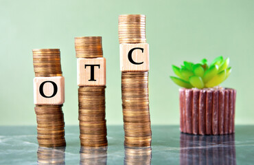 OTC - acronym on wooden cubes on stacks of coins