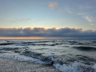 Cloudy day at the Baltic Sea, stormy waves and breakwater on the shore