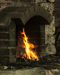 A brick and stone blacksmith's forge with fire