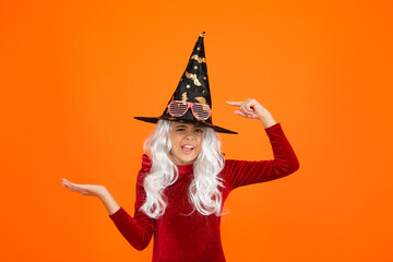 Girl in Halloween point finger on witch costume hat. Happy Halloween. Girl witch in Halloween...
