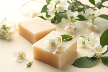Soap bars and jasmine flowers on beige background, closeup