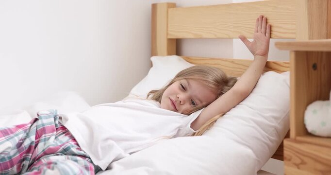 Cute little girl lying in bed at home
