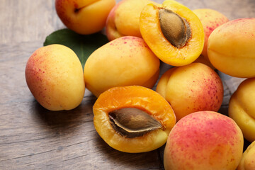 Many fresh apricots on wooden table, closeup