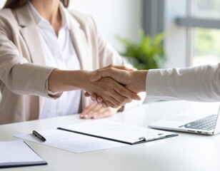 新しい始まり：デスク越しに交わされる採用の握手