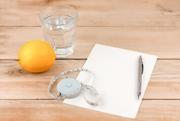 Healthy lifestyle concept. lemon, glass of water, tape measure