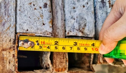 Measuring Old Metal Structure with Tape Measure Close Up View