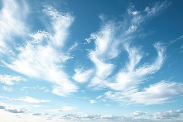 Obraz premium Bright blue sky with scattered wispy white clouds creating a serene and airy atmosphere on a clear day