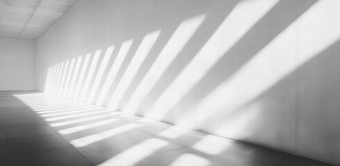 Empty modern minimalistic interior with long diagonal shadows cast by window blinds creating a pattern of light and shade on white walls and floor evoking calm and quiet