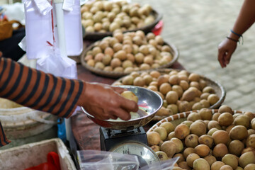 A pile of fresh sapodilla at a traditional market in Balikpapan. buyers are choosing sapodilla...