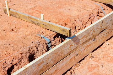 Workers are setting wooden frames for foundation on works day at construction site.