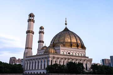 Obraz premium Grand mosque with golden domes and tall minarets.