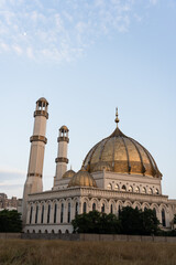 Obraz premium Grand mosque with golden domes and tall minarets.