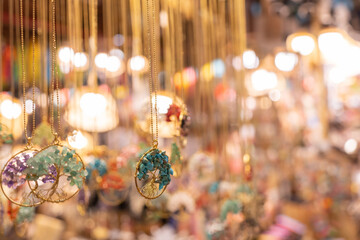 Collection of handcrafted wire-wrapped tree of life pendants hanging on display for sale.