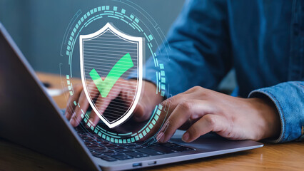Online security concept showing a person using a laptop protected by digital security