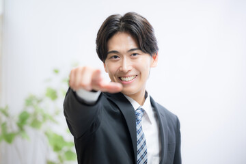 一番を目指して指を差すスーツ姿のビジネスマンカメラ目線