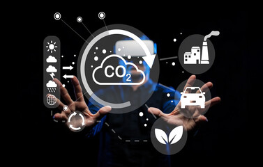 Hands Reaching Out Towards Digital Screen Displaying CO2 Emissions and Environmental Icons for...