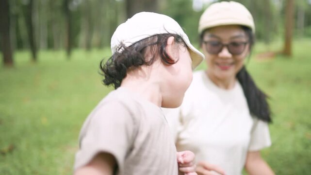 Mother and daughter enjoying quality time outdoors in a green forest, smiling and embracing during a family adventure, capturing love, happiness, companionship, parenting, and childhood.