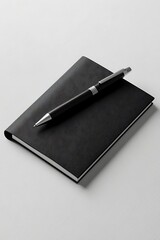 Black notebook with pen, and white background.