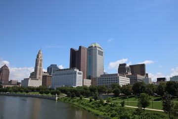 Fototapeta premium Clean and modern urban skyline of downtown Columbus, Ohio, showcasing architectural diversity, city life, and metropolitan identity. A blend of contemporary and historic buildings under clear skies.
