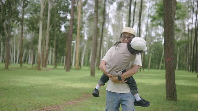 Mother and daughter enjoying quality time outdoors in a green forest, smiling and embracing during a family adventure, capturing love, happiness, companionship, parenting, and childhood.
