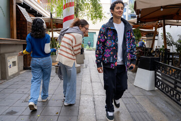Young man walking and attracting attention from friends
