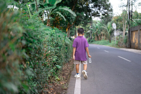 Child walking alone in a city park on a very sunny day. High quality photo