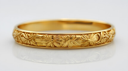 Elegant gold bangle bracelet with floral engravings on white background