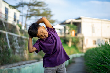 son doing physical workout and warming up before jogging. outdoor sport