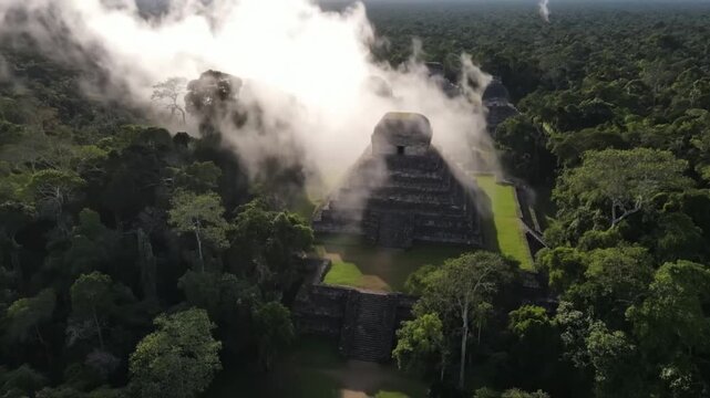 Misty morning reveals ancient mayan pyramids emerging from the dense jungle canopy in tikal, guatemala, offering a breathtaking aerial perspective