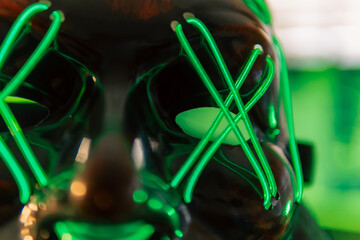 In a dimly lit cyber lair, a glowing hacker mask watches over a desk as encrypted code streams...