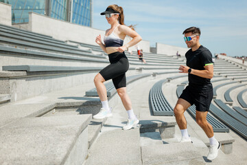 Morning workout session with friends on steps of outdoor stadium under clear blue sky