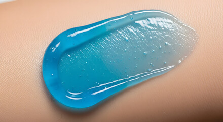 A swatch of light blue translucent toothpaste on skin.