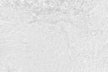 White water with ripples on the surface. Defocus blurred transparent white colored clear calm water surface texture with splashes and bubbles. Water waves with shining pattern texture background.