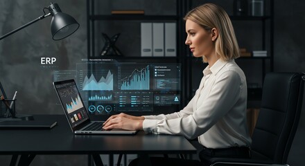 Woman working on laptop with data visualizations in office setting
