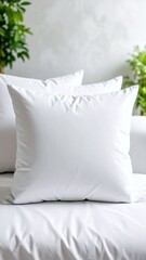 Clean white pillows on a bed with blurred plants.