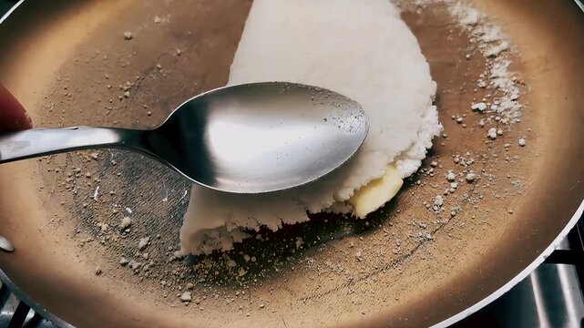 Tapioca with queijo coalho cooking in a frying pan &ndash; close-up shot 